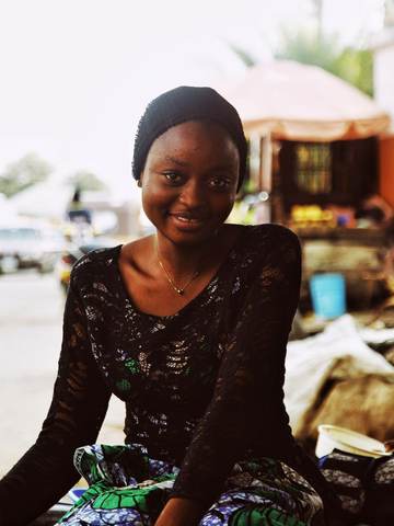 A smiling young woman at her market stall