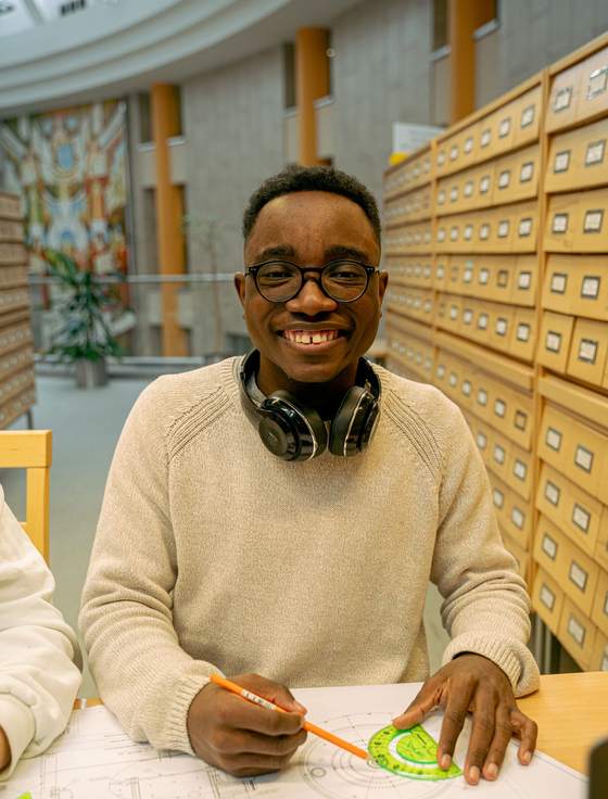 A smiling student working in a university library