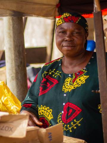 A market vendor smiling at her stall