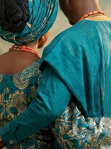 A couple in matching teal aso-ebi