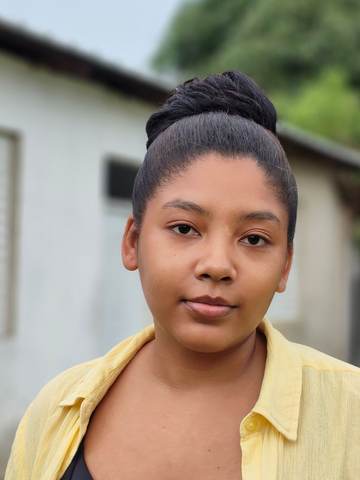 Kemi, a student, outside her home